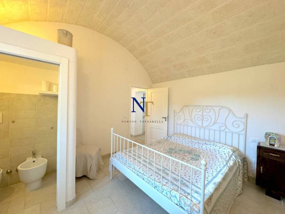 In Puglia te koop trullo en lamia in steen met 2 slaapkamers. Hier slaapkamer met badkamer en-suite in lamia
