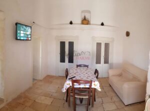 Ostuni, te koop een groepje trulli met NL begeleiding gezellige woonkamer met oude elementen
